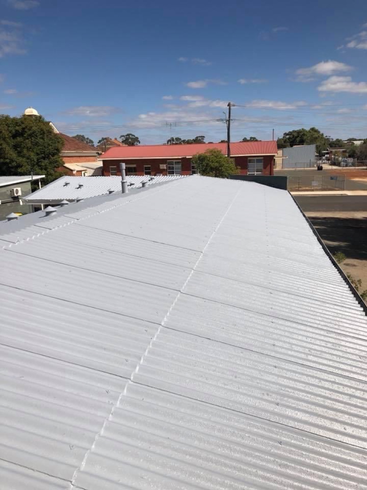 Tired roof recoated bright white, after